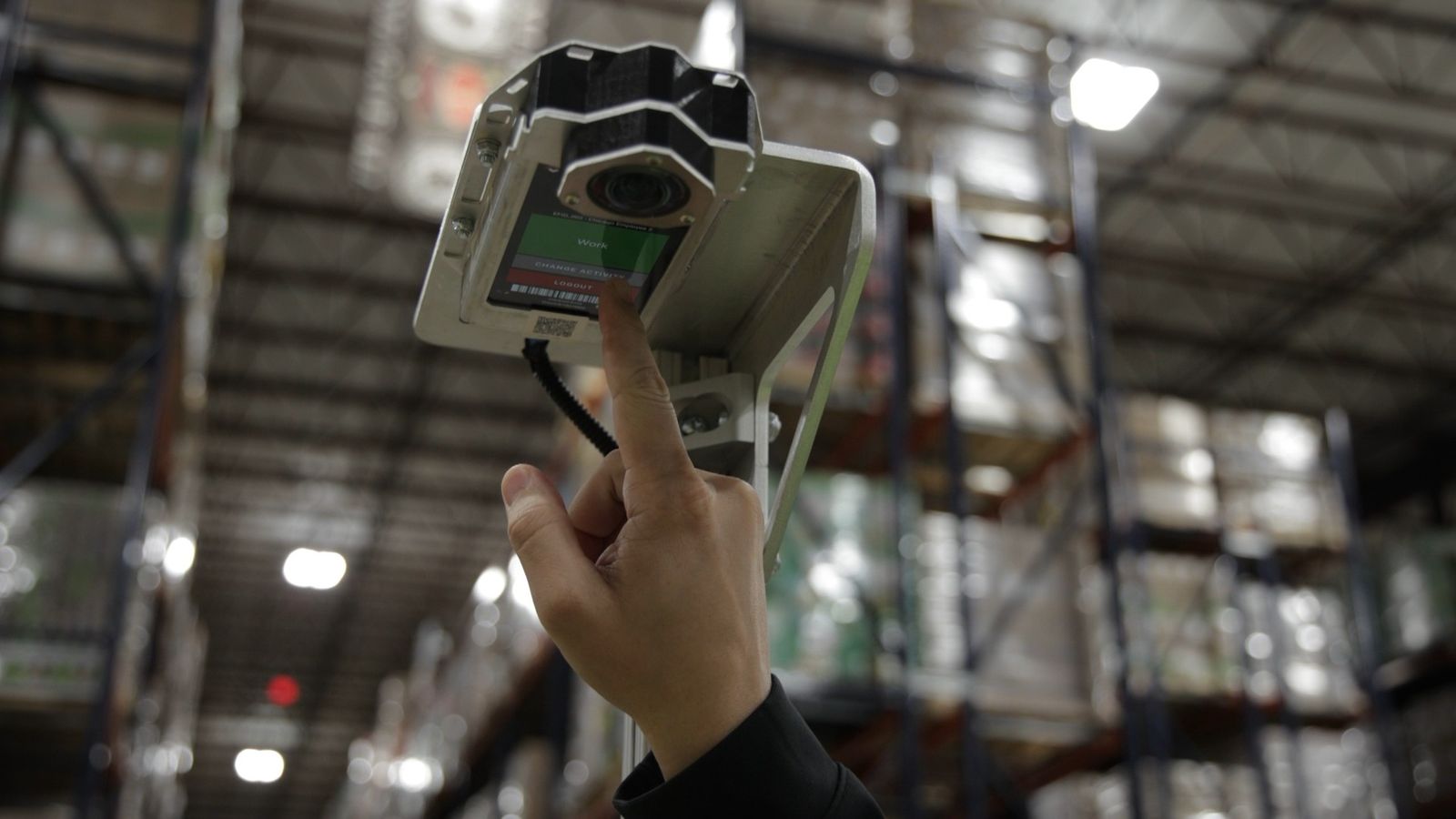 A OneTrack sensor held up in a warehouse