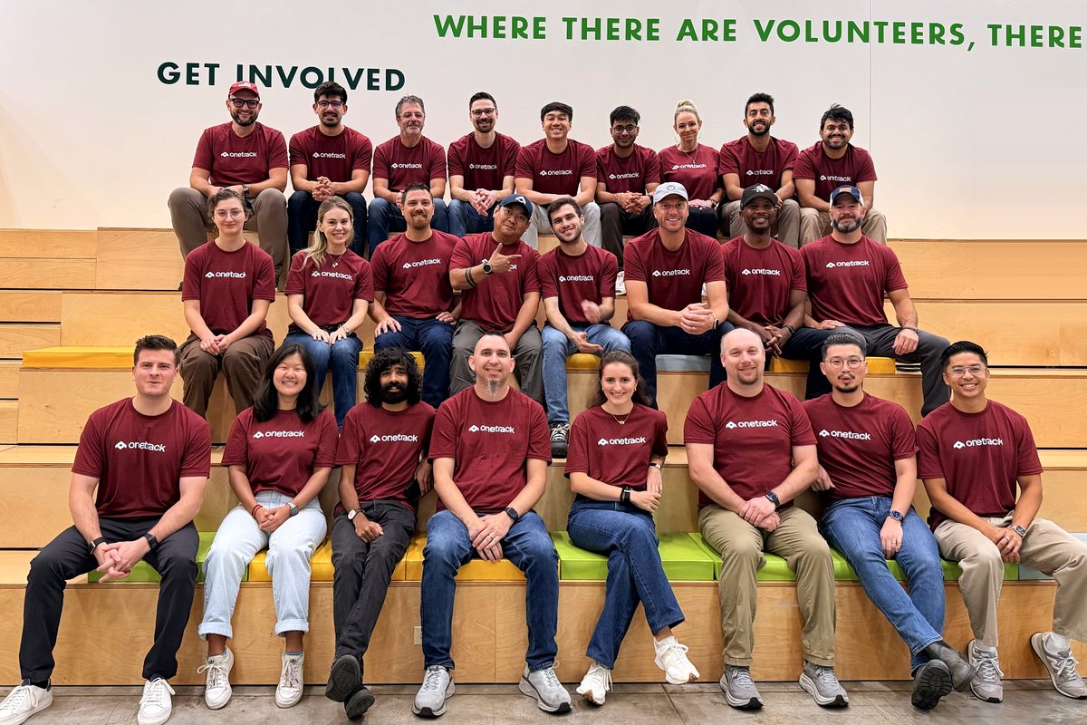 The OneTrack team seated together in matching shirts at a volunteer day