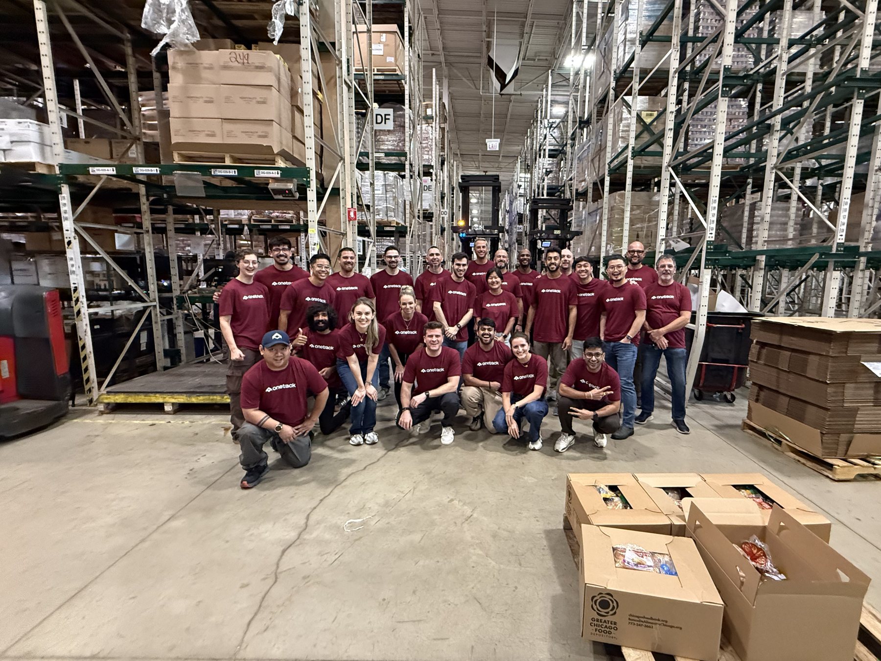 The OneTrack team in matching shirts on a warehouse floor at the 2026 all hands in Chicago