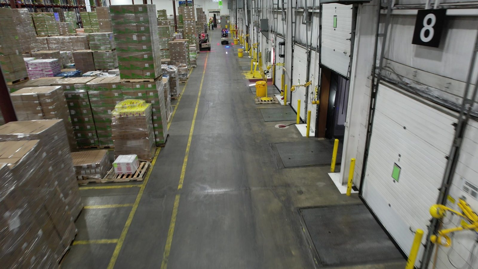 A row of dock doors beside staged pallets in a distribution center