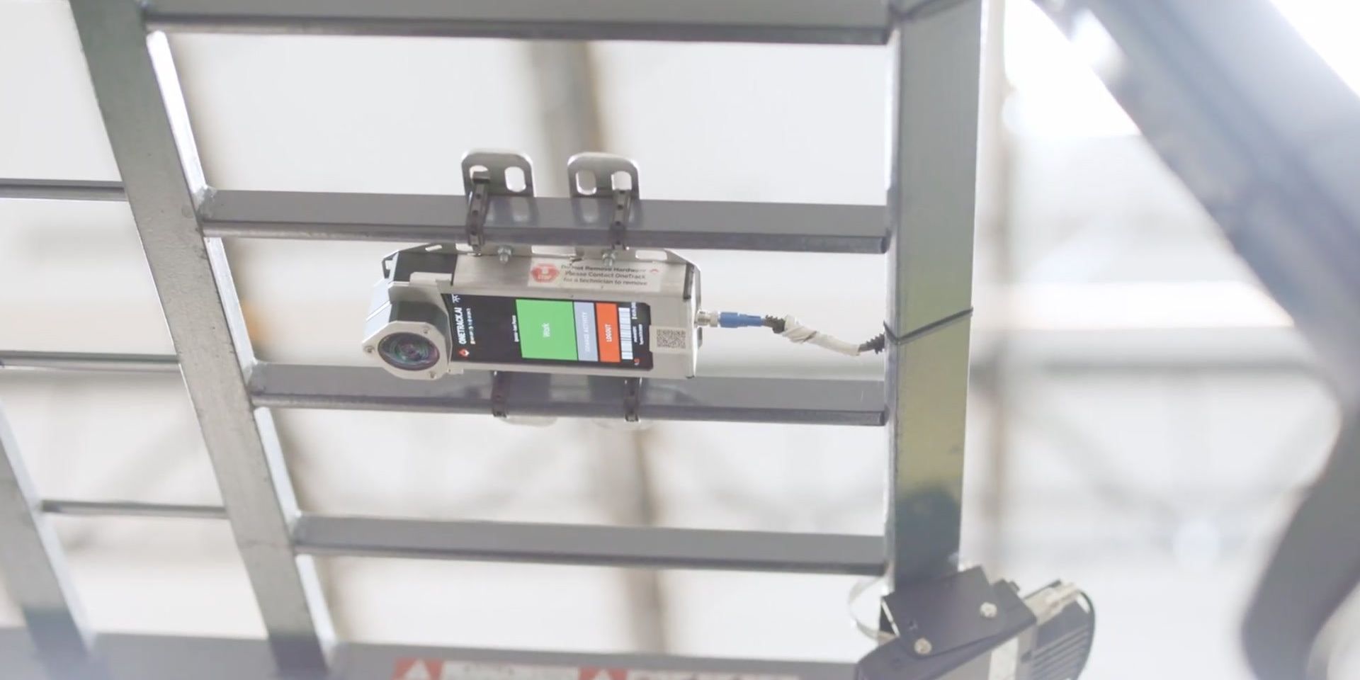 A OneTrack sensor mounted on a forklift's overhead guard, seen from below